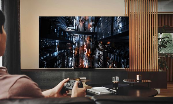 Mies pelaa videopeliä Samsung Neo QLED -pelitelevisiollaan pienellä tuloviiveellä