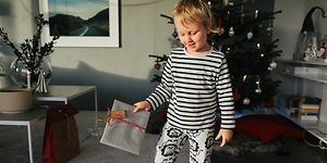 Joululahjat lapsille - Pieni poika pitelee joululahjaa kädessään