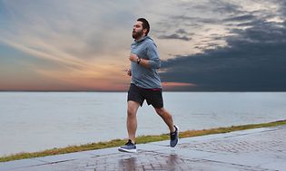 Garmin - Forerunner - Mies juoksemassa veden äärellä