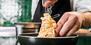 Kokki asettaa pastaa lautaselle