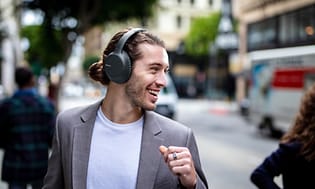 Mies kävelee kadulla Sony-kuulokkeet korvillaan