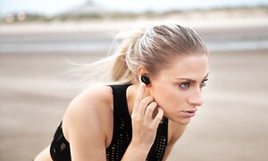 Nainen Bose-kuulokkeet korvissa rannalla