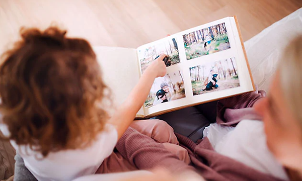 Valokuvatulostin - nainen ja lapsi katsovat valokuva-albumia yhdessä