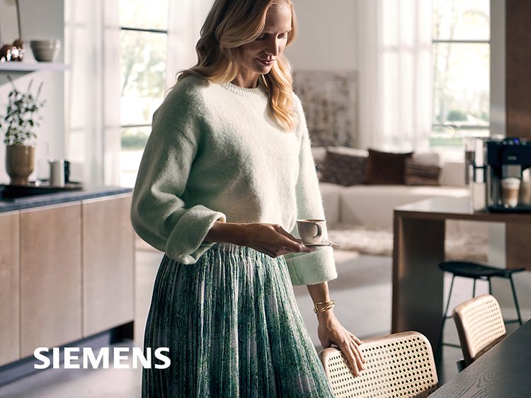 Nainen istuutumassa pöydän ääreen nauttimaan espressoa