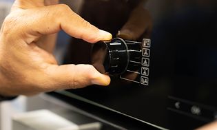 Mies säätää uunin nuppia