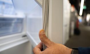 Miehen käsi hieroo jääkaapin kumitiivistettä