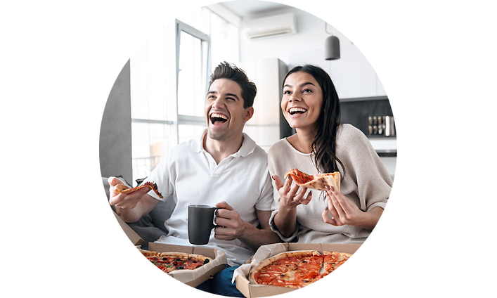 Nainen ja mies syövät pizzaa television edessä