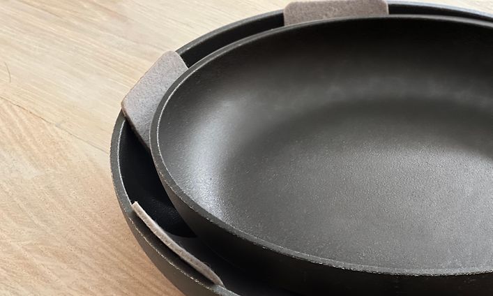 Pannuja pinottuna päällekkäin suojien kanssa