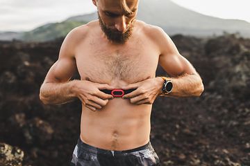 A man attaching a heart rate monitor to his chest