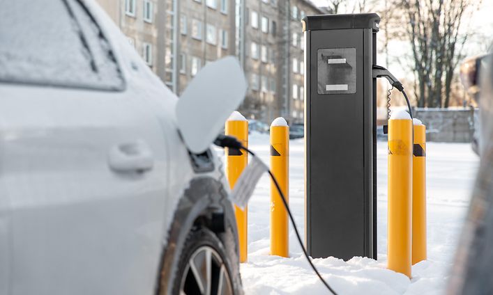 Auto kiinni laturissa talvimaisemassa