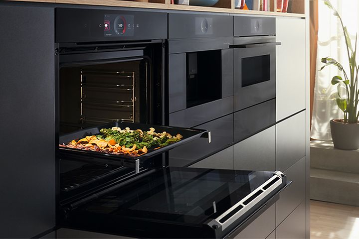 Bosch accent line -uuni luukku raollaan ja uunipellillinen kasviksia