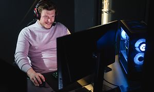 Gaming - Pelitietokoneet - Hymyilevä mies pelaa tietokoneella