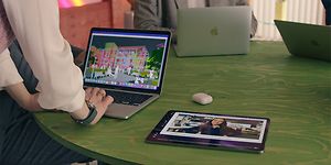 Apple Business Manager - vihreällä pöydällä esillä MacBook-tietokoneita, iPadeja ja Airpodeja