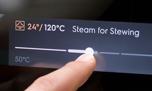 Electrolux-uuni Steamify-toiminnolla ja sormi valitsemassa lämpötilaa ohjauspaneelilla