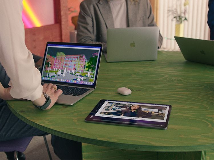 MacBook-kannettavia, iPadeja ja Airpodeja pöydällä