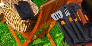 Erilaisia grillausvälineitä nurmikolla piknik-korin vieressä