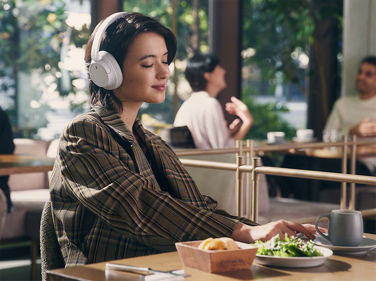 Naishenkilö miellyttäväkäyttöiset Sony WH-CH720 -kuulokkeet päässään