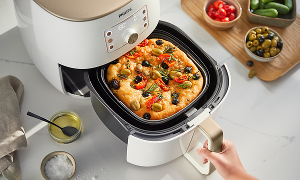 Valkoinen Philips Airfryer XXL ja ruokaa valmistumassa sen paistoalustalla