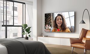 Seinään asennettu QLED770-televisio olohuoneessa sekä Google Duo käytössä ruudulla