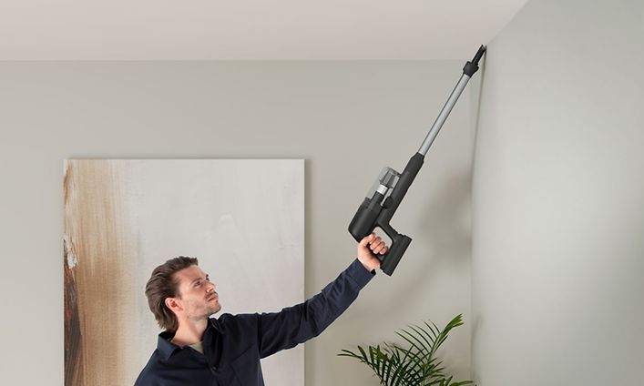 Electrolux - Johdoton varsi-imuri - Henkilö imuroimassa katon rajaa