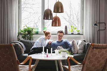 Sohvalla istuva pariskunta katsoo yhdessä puhelinta