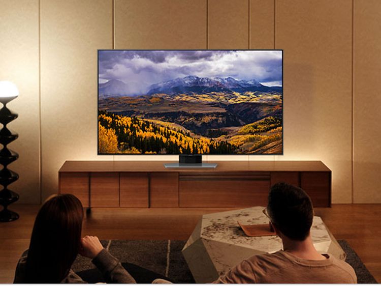 Pariskunta katselee Samsung-televisiota ja nauttivat TV-kokemuksesta voimistavista väreistä