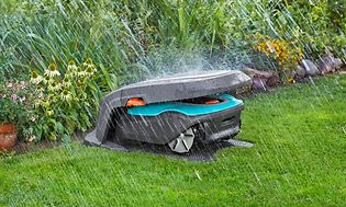Robottiruohonleikkuri Gardena-merkkisessä tallissaan sateensuojassa