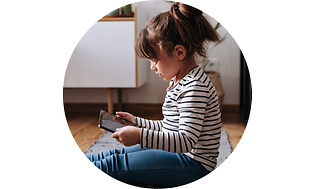 Pieni tyttö istuu lattialla ja käyttää tablettia