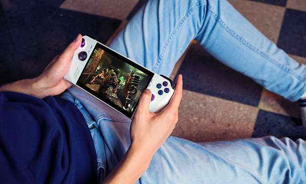 Mies chilliaa lattialla ja pelaa Asus ROG Ally -käsikonsolilla
