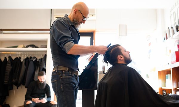 B2B - Parturi-kampaaja leikkaamassa miehen hiuksia