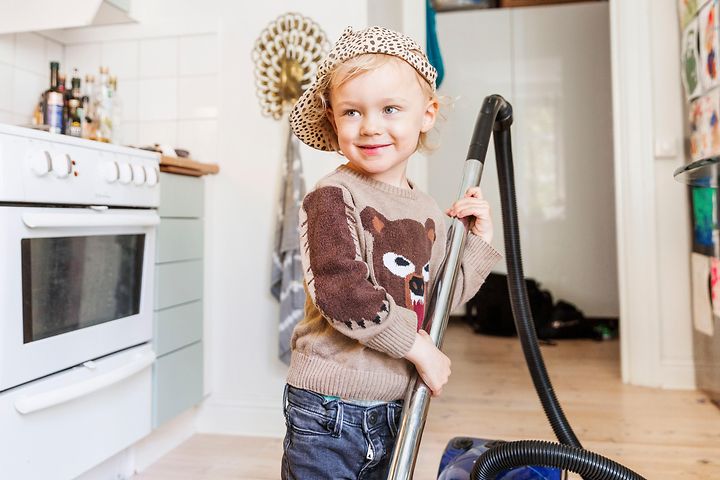 Keittiössä oleva lapsi imuroimassa