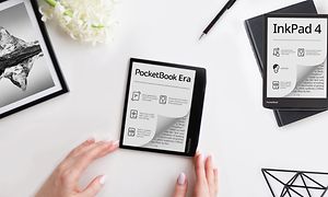 Pöydällä oleva Pocketbook-e-kirjanlukija sekä kädet, kukka, kynä, taulu ja toinen Pocketbook-e-kirjanlukija ympärillään