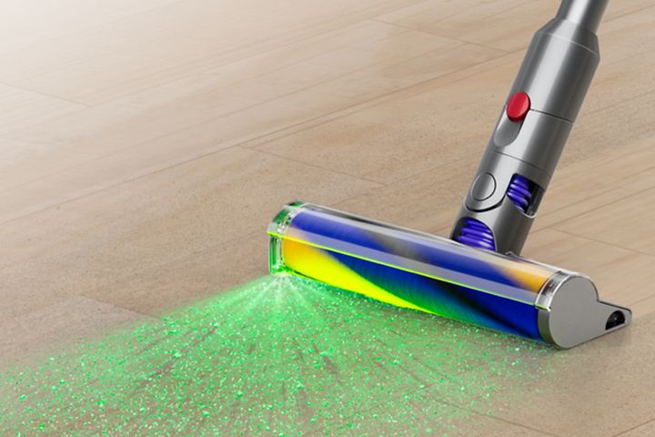 Dyson V15 -imurin Fluffy Optic -valaiseva suulake, johon on kuvitettu imurin heijastamia vihreitä valonsäteitä