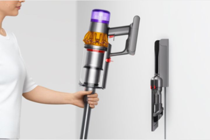 Nainen asettamassa Dyson V15 Submarine -imuria lataustelakkaan