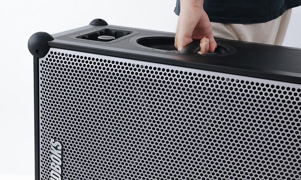 Mies kantaa Soundboks 4 -kaiutinta sen kantokahvasta