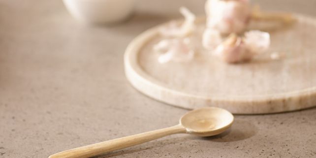 Epoq Dekton-työtasolla oleva lusikka ja lautanen, jossa on valkosipulia