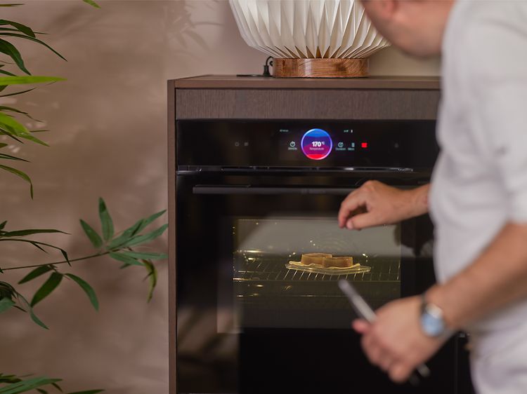 Kokki höyryttää kalaa Bosch accent line -uunin höyrytystoiminnolla