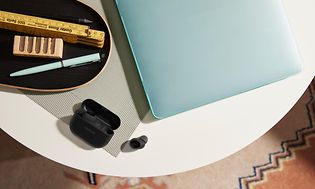 Jabra Elite 10 -kuulokkeet pöydällä kannettavan tietokoneen vieressä