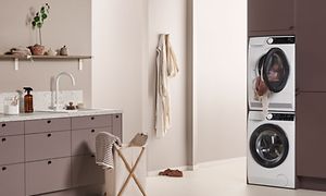 EPOQ - Kodinhoitohuone - Sisutukseltaan beigen sävyinen kodinhoitohuone, jossa integroidut pesukone ja kuivausrumpu