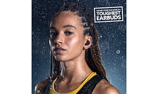 Urheiluvaatteisiin pukeutunut nainen Jabra Elite 8 Active -kuulokkeet korvissaan
