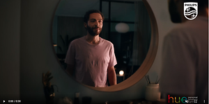 Philips Hue -videon kuvakaappaus, jossa mies seisoo katsomassa itseään peilin edessä