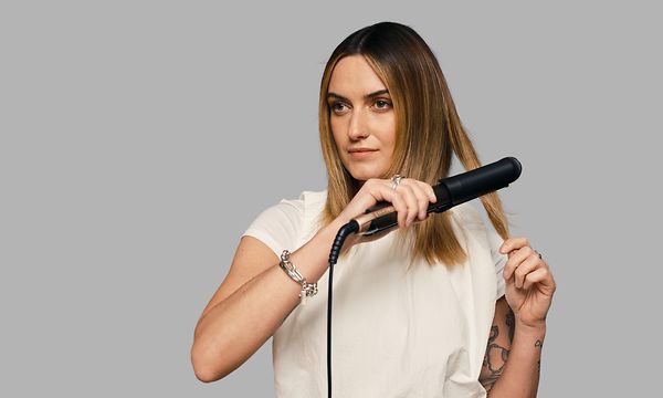 Nainen käyttää Remington ONE Straight & Curl -muotoilurautaa hiustensa muotoilemiseen