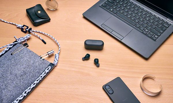 Sony WF-C510 -kuulokkeet pöydällä läppärin ja älypuhelimen vieressä