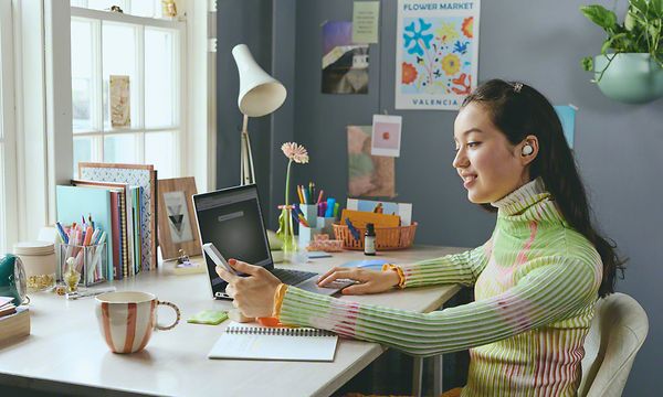 Tyttö työpöydän ääressä Sony WF-C510 -kuulokkeet korvissaan