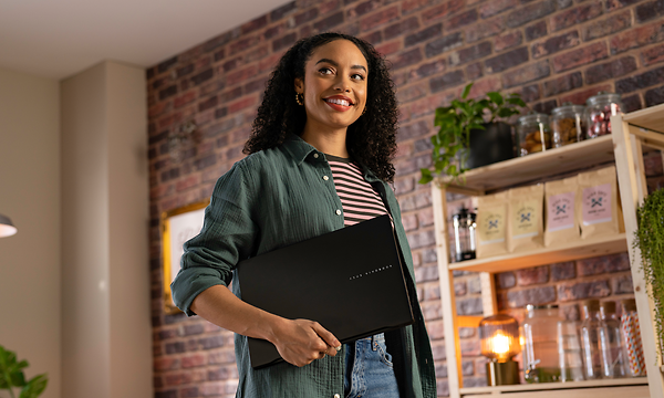 Nainen ja Asus Vivobook S 14 M5406 OLED kannettava tietokone kainalossaan