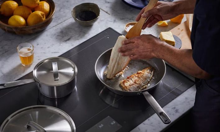 Kalaa kypsymässä teräksisellä Fiskars All Steel -paistinpannulla