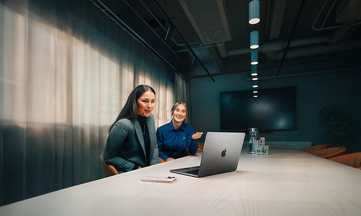 Gigantin yritysneuvonataja auttaa naispuolista yritysasiakastaan MacBook Air -tietokoneen käytössä