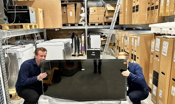 TV pakkauksessa - Kaksi miestä purkaa televisiota pakkauksesta