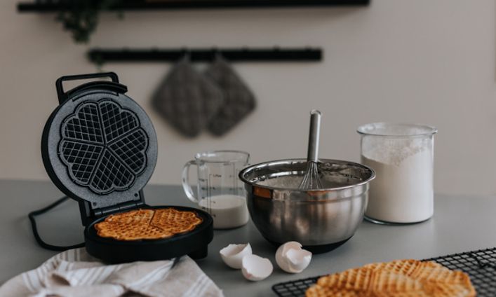 Keittiön työtasolla oleva vohvelirauta ja kulhollinen vohvelitaikinaa