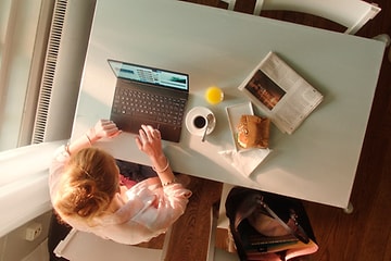 nainen kannettavan tietokoneen ääressä lounas pöydällä